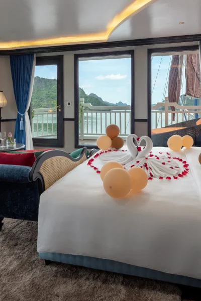 romantic cruise cabin with large windows, swan towel art, rose petals, and scenic ocean views