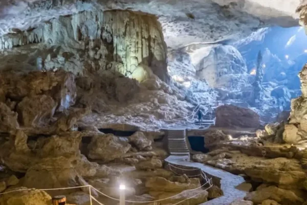 Natural cave interior with stone pathway, rock formations, and soft lighting